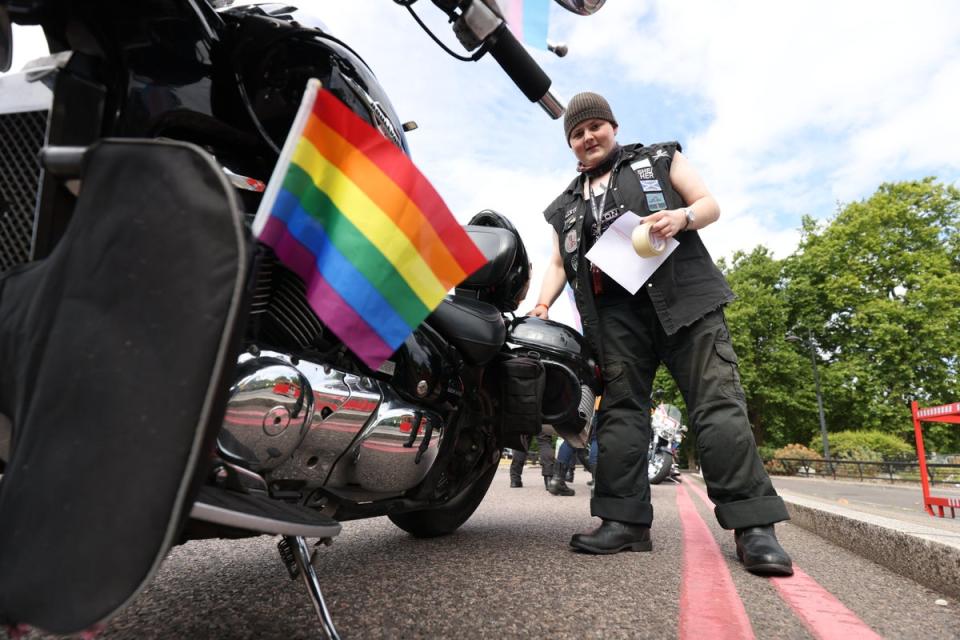 Valkyrie from Gloucester attaches Pride decorations to a motorbike (James Manning/PA) (PA Wire)