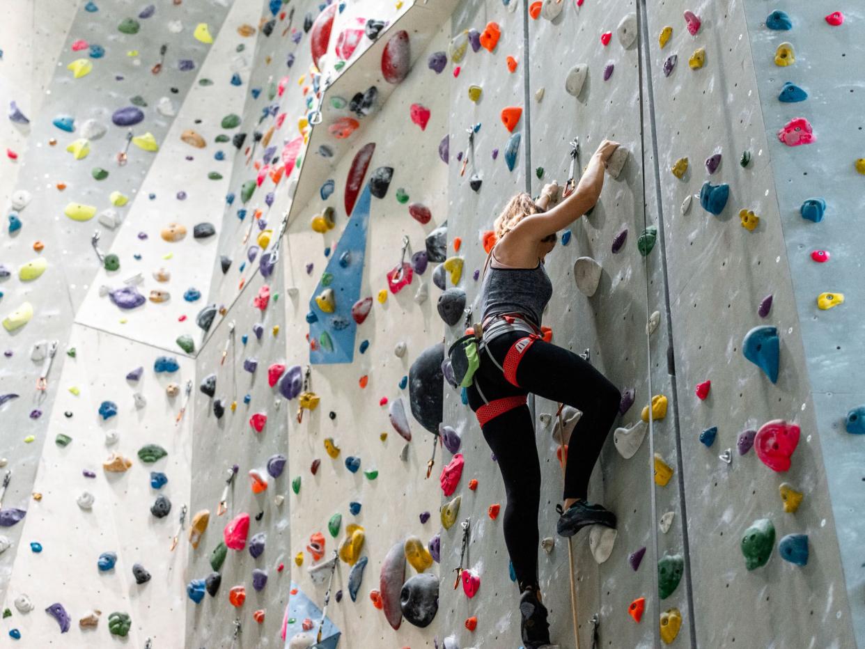 Woman climbing on climbing wall. Climbing gym.