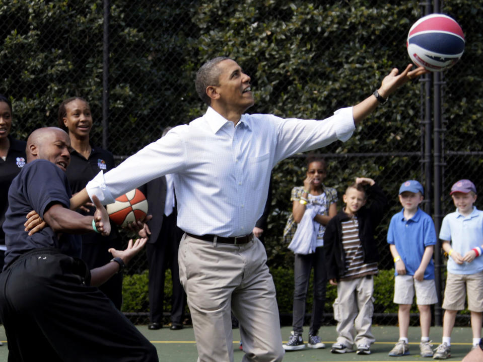 FILE - President Barack Obama, front right, plays basketball with former NBA basketball player Bruce Bowen, front left, during the annual White House Easter Egg Roll at the White House in Washington, April 9, 2012. Former President Obama returned to Cambridge, Mass., Friday, Sept. 9, 2022, to attend “The Breakfast Club,” a group formed by Harvard basketball coach Tommy Amaker with law professors Charles Ogletree and Ron Sullivan to create a community of Black leaders and connect it with his team. (AP Photo/Carolyn Kaster, File)