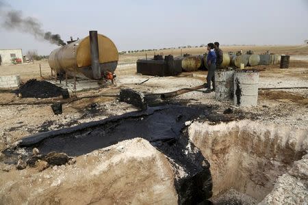 Men work at a makeshift oil refinery site in Marchmarin town, southern countryside of Idlib, Syria in this December 16, 2015, file photo. REUTERS/Khalil Ashawi