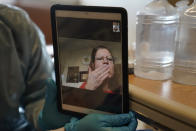 Sharie Duran blows a kiss to her mother, a COVID-19 patient, while on a video chat arranged by chaplain Kevin Deegan at Providence Holy Cross Medical Center in the Mission Hills section of Los Angeles on Saturday, Jan. 9, 2021. "We need new words to describe where we are at now," said Deegan. "This whole month has just been so far beyond anything I had expected." (AP Photo/Jae C. Hong)