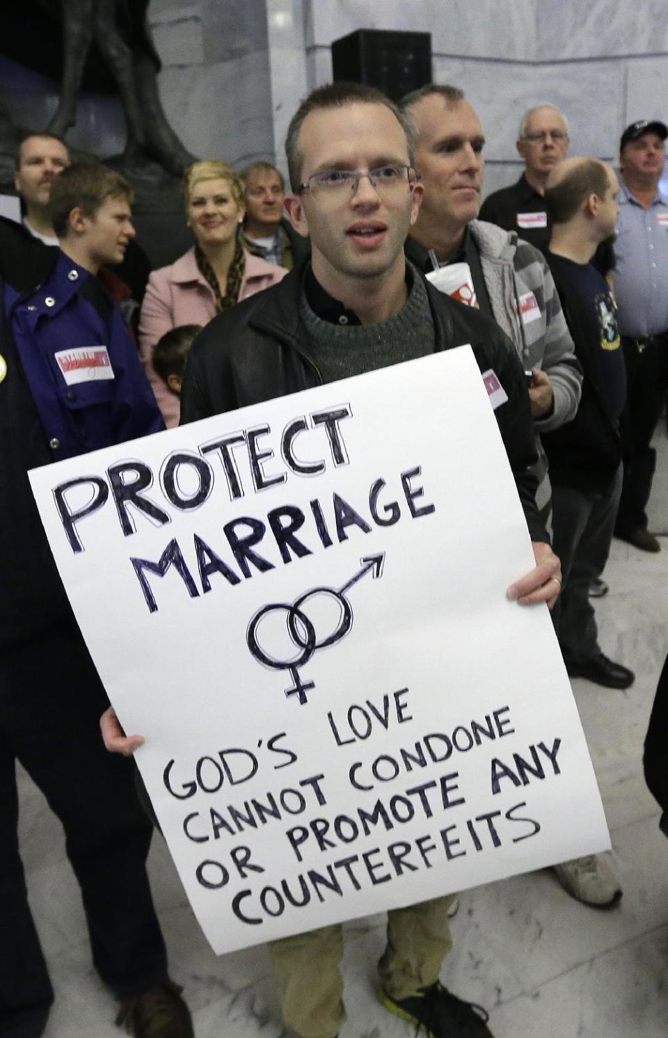 Dan Lyle, of Payson, shows his supports during a rally for the opponents of gay marriage at the Utah State Capitol Tuesday, Jan. 28, 2014, in Salt Lake City. Opponents and supporters of gay marriage held twin rallies at the Utah State Capitol on Tuesday evening. The opposing gatherings are the latest square-off over gay marriage, an issue that took Utah by surprise over the past month. More than 1,000 gay couples rushed to wed when a federal judge overturned Utah's constitutional amendment banning same-sex marriage in late December. Voters approved the amendment in 2004. Same-sex marriages continued in Utah until early January, when the U.S. Supreme Court granted Utah's request for an emergency halt to the weddings. (AP Photo/Rick Bowmer)