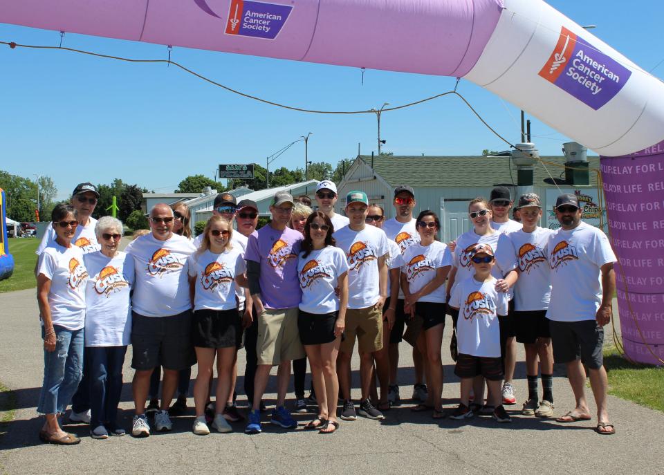 Wearing a purple T-shirt, Scott Assenmacher of Ida is surrounded by his family. Assenmacher, who will turn 48 in August, was diagnosed with Hodgkin’s Disease when he was 12. A little more than a year ago, he was diagnosed with Stage 4 lung cancer.