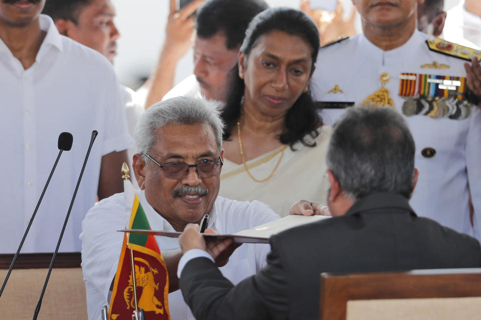 FILE - Then Sri Lanka's newly elected president Gotabaya Rajapaksa, center, hands over oath taking documents to Chief Justice Jayantha Jayasuriya as his wife Ayoma watches during his swearing in ceremony held at the 140 B.C Ruwanweli Seya Buddhist temple in ancient kingdom of Anuradhapura in northcentral Sri Lanka Monday, Nov. 18, 2019. The president of Sri Lanka fled the country early Wednesday, July 13, 2022, days after protesters stormed his home and office and the official residence of his prime minister amid a three-month economic crisis that triggered severe shortages of food and fuel.(AP Photo/Eranga Jayawardena, File)
