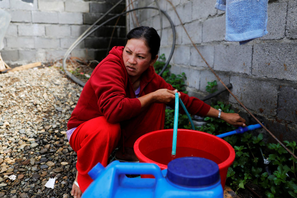 Marie Dalama Acampong, 37, fills containers with water at the only water source near the school-turned-evacuation center in Mipaga, Marawi City, Lanao del Sur province, Philippines. (Photo: Eloisa Lopez/Reuters)