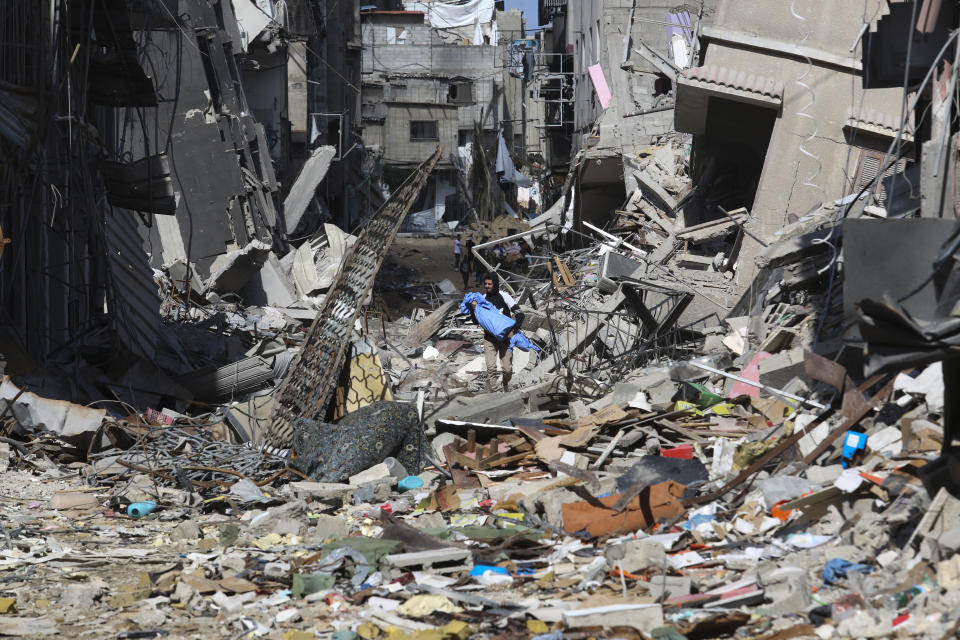 A Palestinian walks through the destruction left by the Israeli offensive on Khan Younis, Gaza Strip, Friday, March 8, 2024. (AP Photo/Hatem Ali)