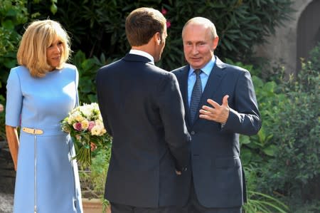 French President Emmanuel Macron and his wife Brigitte Macron welcome Russia's President Vladimir Putin, at the French President's summer retreat of the Bregancon fortress on the Mediterranean coast, near the village of Bormes-les-Mimosas