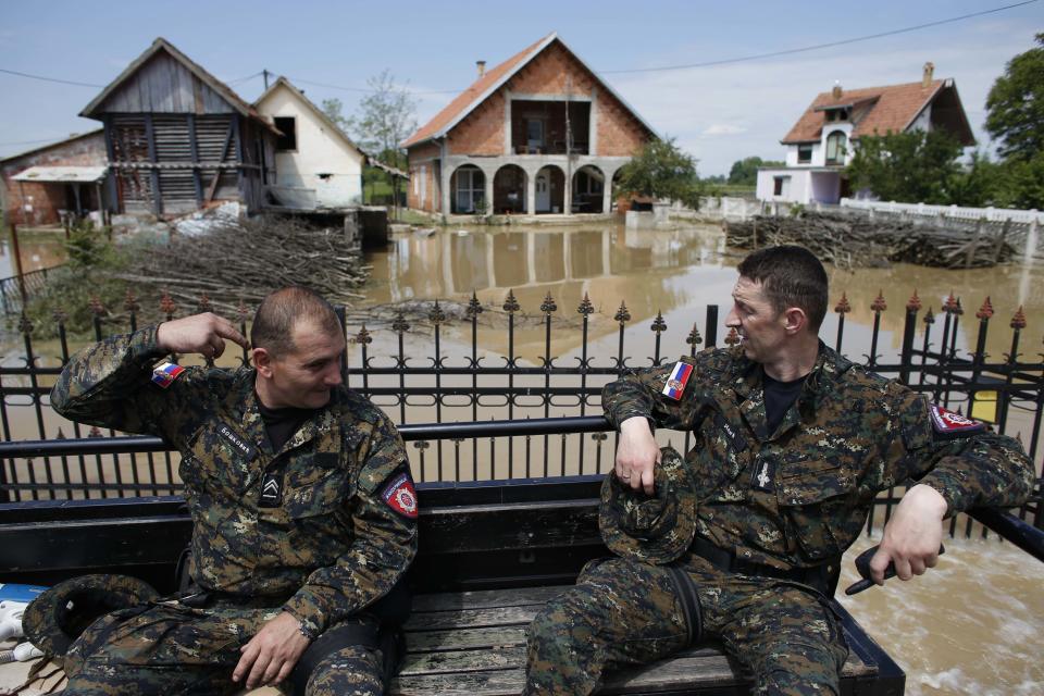 Serbian "Gendarmerie" police officers travel on a truck through a flooded street in Obrenovac