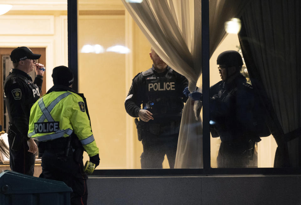 Police stand in the lobby of a condominium building following a shooting in Vaughan, Ontario, Sunday, Dec. 18, 2022. Authorities said multiple people were shot and killed in a unit of the building in the Toronto suburb and the gunman was killed by police. (Arlyn McAdorey/The Canadian Press via AP)