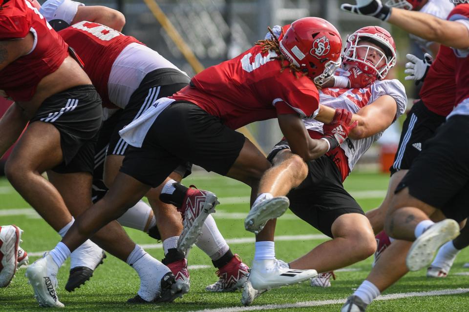 USD defensive back Teven McKelvey tackles another player during football practice at University of South Dakota in Vermillion, South Dakota on Wednesday, Aug. 9, 2023.