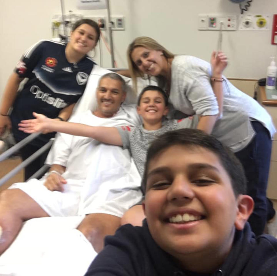 Pictured is Melbourne dad Adrian Nandapi in his hospital bed, supported by his family who are happy for his recovery from the flesh-eating bacteria..