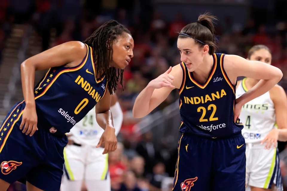 Caitlin Clark, No. 22, of the Indiana Fever speaks with Kelsey Mitchell, No. 0, during the first half against the Dallas Wings Sept. 15 in Indianapolis. Clark and Mitchell have made a dynamic duo for the Fever in 2024.