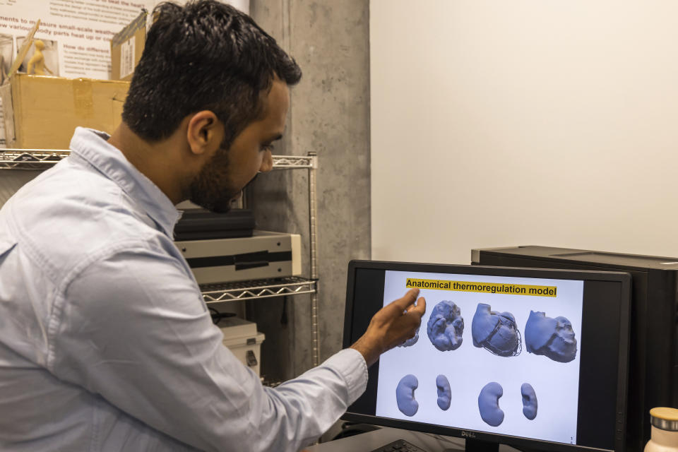 In this May 5, 2023, image provided by Arizona State University, researcher Ankit Joshi demonstrates how ANDI the thermal mannequin works at the Human Biometeorology Lab, in Tempe, Ariz. (Christopher Goulet/ASU via AP)