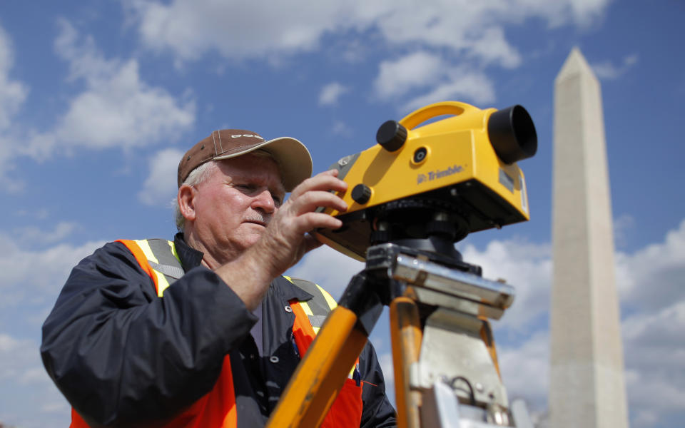 David Bruce Crockett, a geodesist with the National Oceanic and Atmospheric Administration (NOAA) National Geodetic Survey uses an instrument to measure elevation on the National Mall, with the Washington Monument in the background, Tuesday, March 13, 2012, in Washington. Government surveyors are collecting data around the Washington Monument and other sites on the National Mall that will reveal whether it has sunk or tilted since last year's earthquake. (AP Photo/Charles Dharapak)