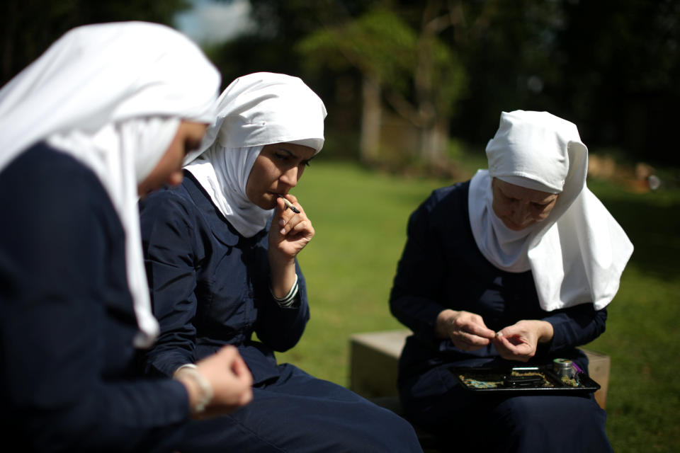 California "weed nun" Christine Meeusen, 57, (R), Desiree Calderon, who goes by the name Sister Freya (L), and India Delgado, who goes by the name Sister Eevee, smoke at Sisters of the Valley near Merced, California, U.S., April 18, 2017. Picture taken April 18, 2017. REUTERS/Lucy Nicholson