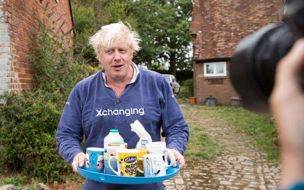 Boris Johnson, a possible leadership rival, brings tea for the press to drink outside his house in Thame - PA