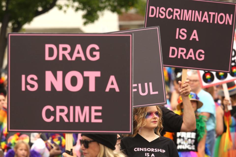 People holding signs in a crowd