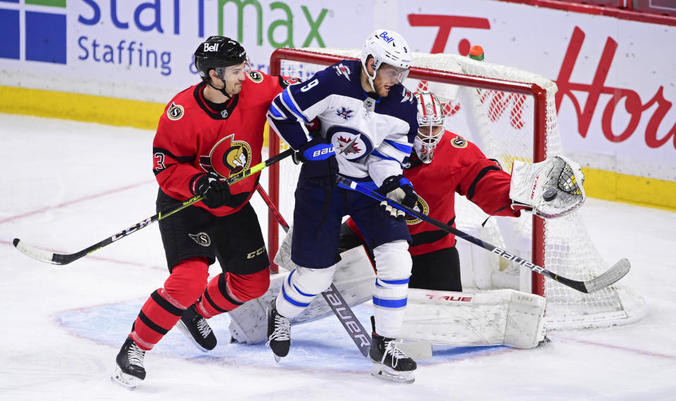 Ottawa Senators goaltender Matt Murray (30) makes a glove save as Senators' Josh Brown (3) defends against Winnipeg Jets' Andrew Copp (9) during the second period of an NHL hockey game Wednesday, April 14, 2021, in Ottawa, Ontario. (Sean Kilpatrick/The Canadian Press via AP)