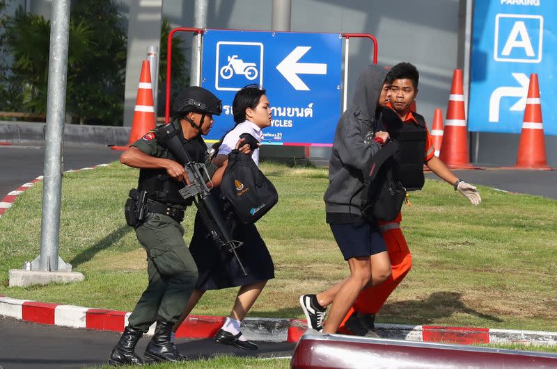 Thai security forces evacuate students stranded inside the Terminal 21 shopping mall following a gun battle to try to stop a soldier on a rampage after a mass shooting, Nakhon Ratchasima