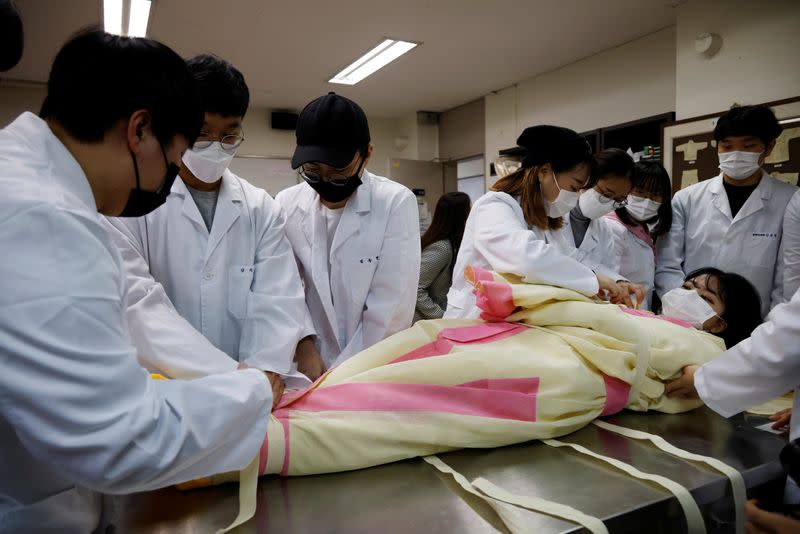 Park Se-jung who majors the funeral directing at Eulji University, is laid for practice of how to shroud the deceased during a class, in Seongnam