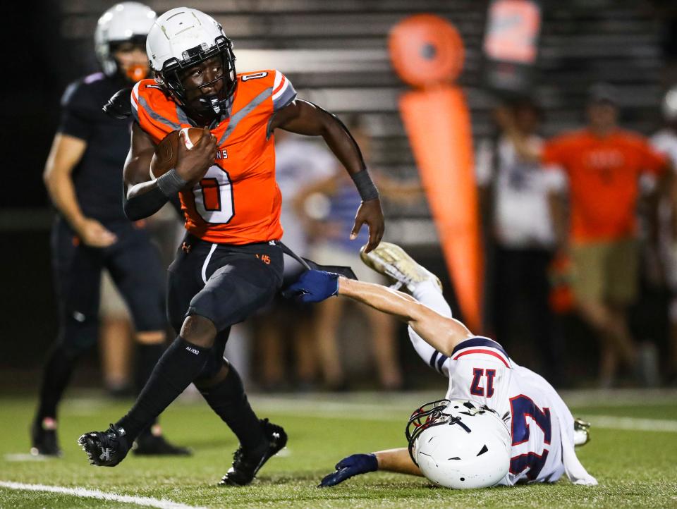 Lely Trojans running back Jayvian Tanelus (0) breaks a tackle from Estero Wildcats linebacker Kyle King (17) in the backfield during the third quarter of a spring football game at Lely High School on Friday, May 19, 2023. Tanelus transferred to CSN for the 2024 season.