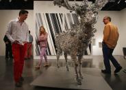 MIAMI BEACH, FL - DECEMBER 05: People look at a piece of art in the Scai The Bathhouse gallery as Art Basel opens at the Miami Beach Convention Center on December 5, 2012 in Miami Beach, Florida. The 11th edition of the art show runs from December 6 through the 9th. (Photo by Joe Raedle/Getty Images)