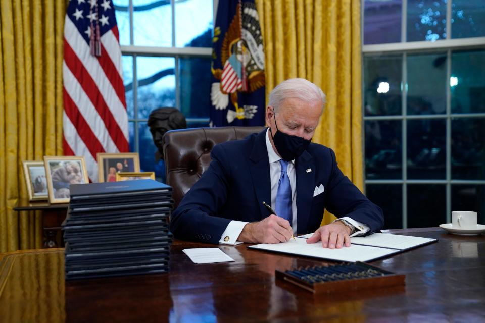 FILE - In this Jan. 20, 2021, file photo, President Joe Biden signs his first executive order in the Oval Office of the White House in Washington. Biden laid out an ambitious agenda for his first 100 days in office, promising swift action on everything from climate change to immigration reform to the coronavirus pandemic. (AP Photo/Evan Vucci, File) ORG XMIT: WX209