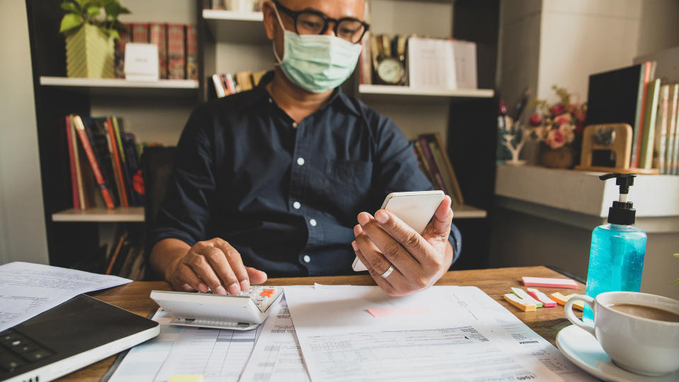 man working on taxes with coronavirus mask