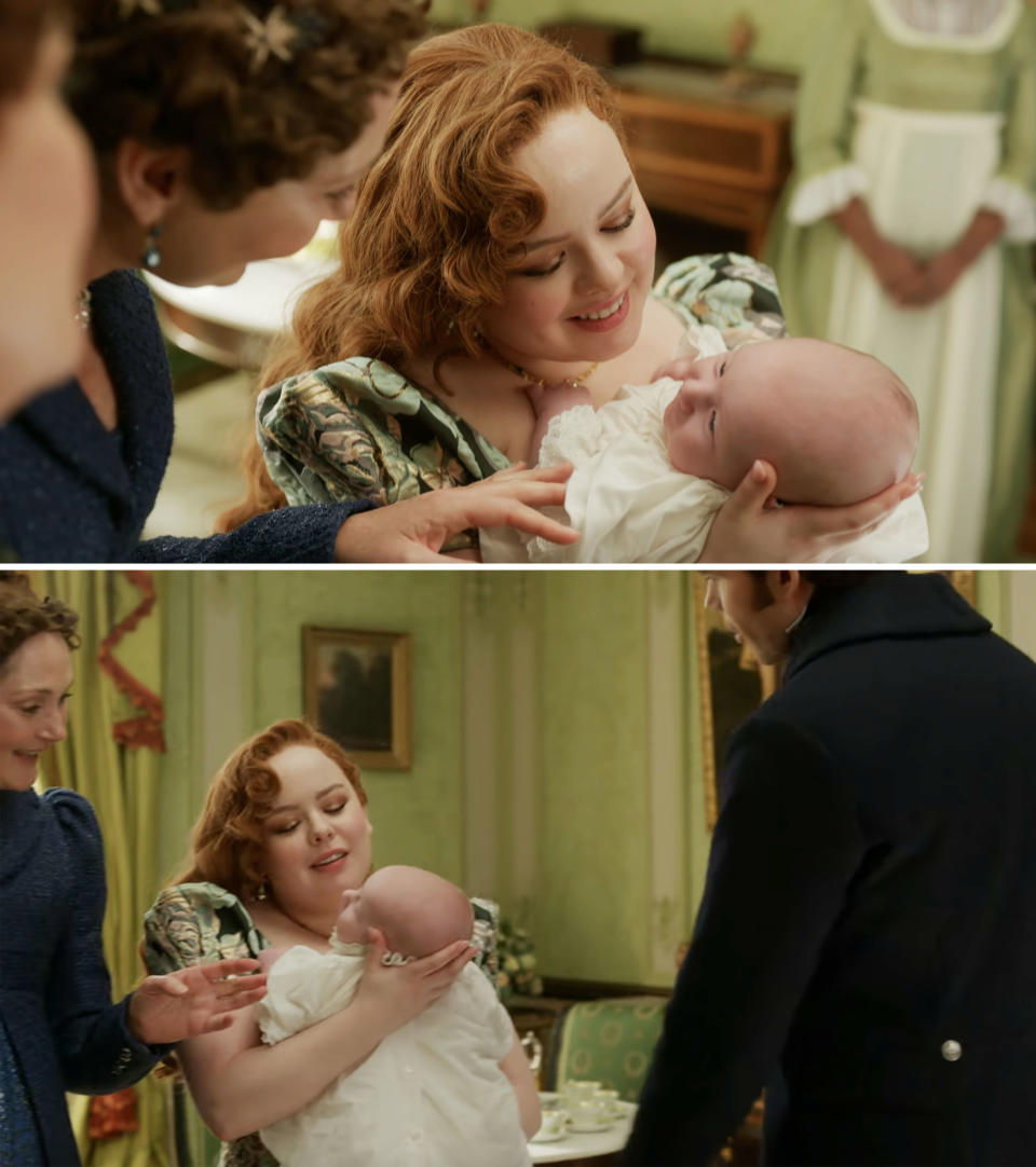 Nicola Coughlan in period costume holds a baby in her arms while Polly Walker and another woman interact with them