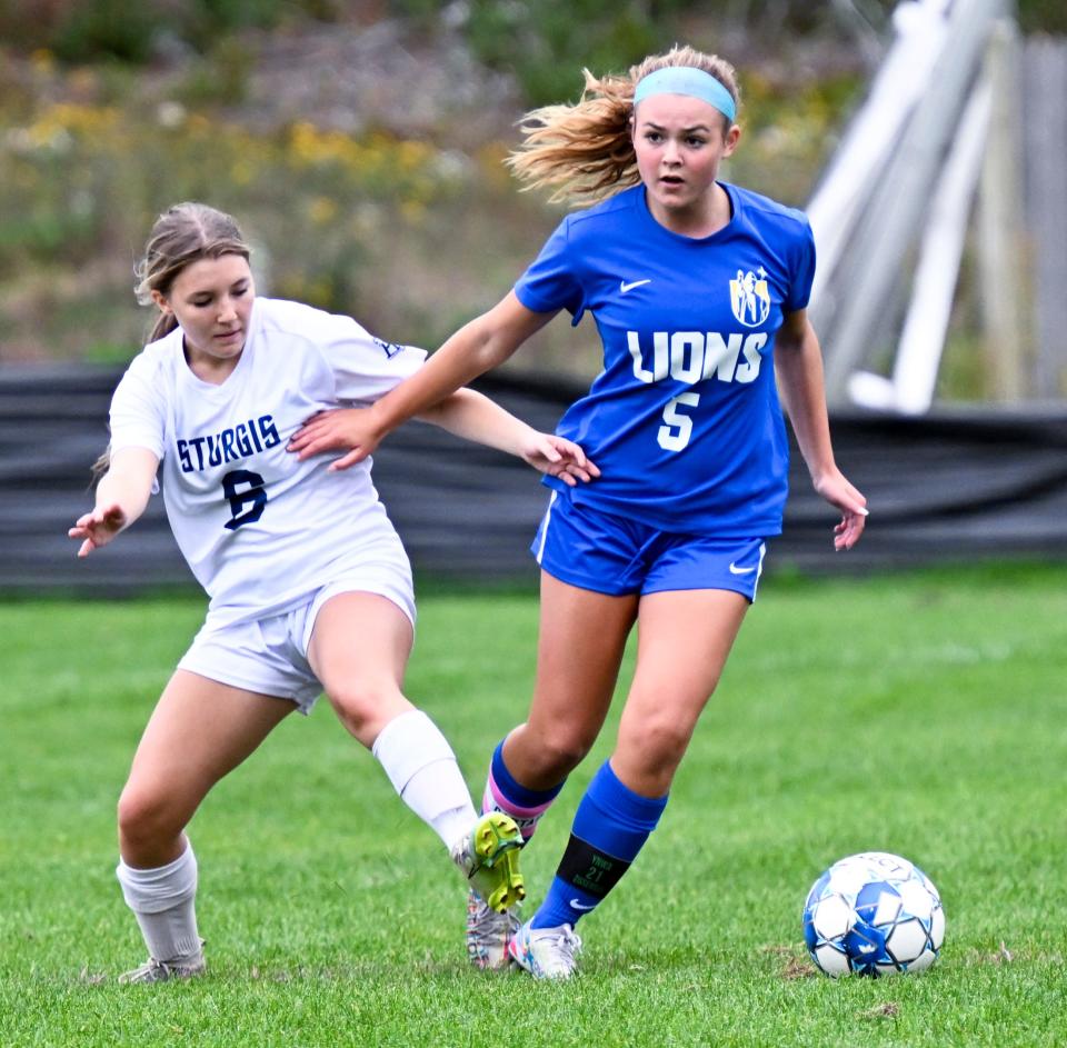 In this October 2022 photo, Ella Cheney of St. John Paul II attempts to get past Charlotte Westberg of Sturgis East.