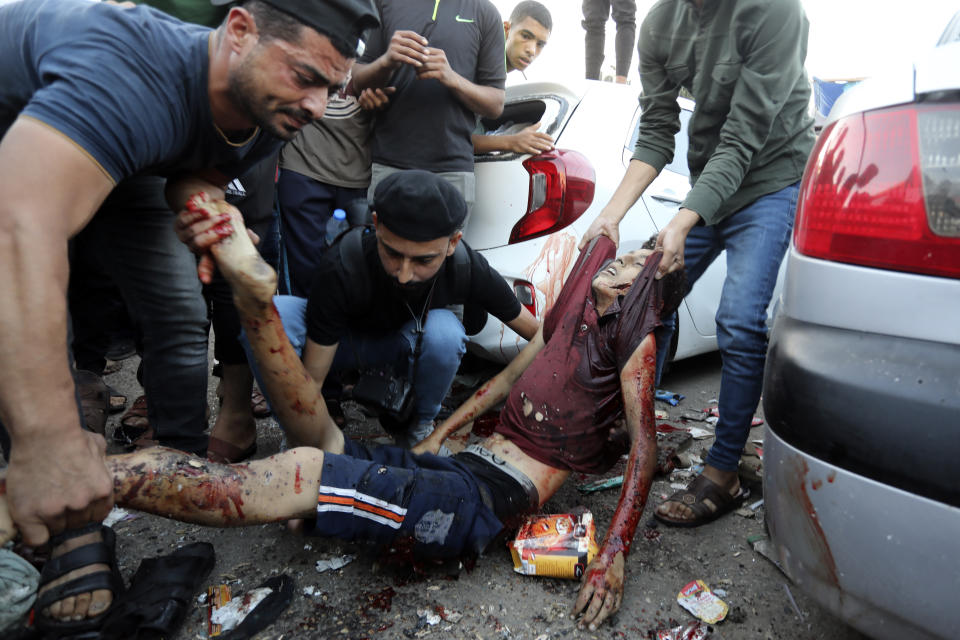 A dead Palestinian man is carried following an Israeli airstrike outside the entrance of the al-Shifa hospital in Gaza City, Friday, Nov. 3, 2023. (AP Photo/Abed Khaled)