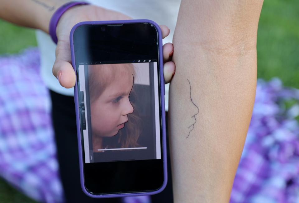 Catrina Nelson shows one of the tattoos she has in memory of her daughter Charlee Nelson at Holladay Cemetery in Holladay on Friday, June 30, 2023. Charlee died at age 6 of Batten disease, just days after Charlee’s Law was passed in her name, making medical cannabis legal in Utah. Charlee never got the chance to try medical cannabis herself. | Kristin Murphy, Deseret News