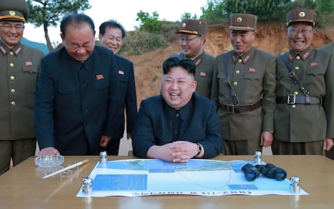 North Korean leader Kim Jong Un reacts during the long-range strategic ballistic rocket Hwasong-12 (Mars-12) test launch in May - Credit: Reuters