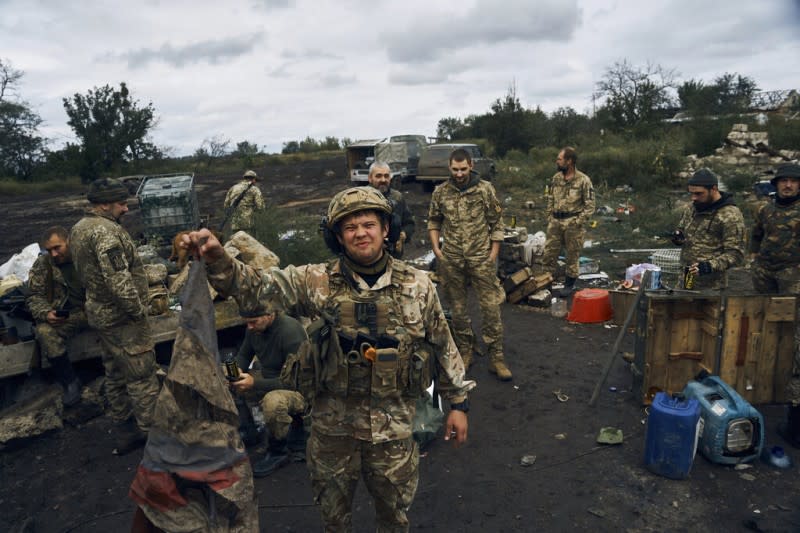 2022年9月13日，一名烏克蘭士兵在伊久姆舉起逃走俄軍拋下的俄羅斯國旗。（美聯社）