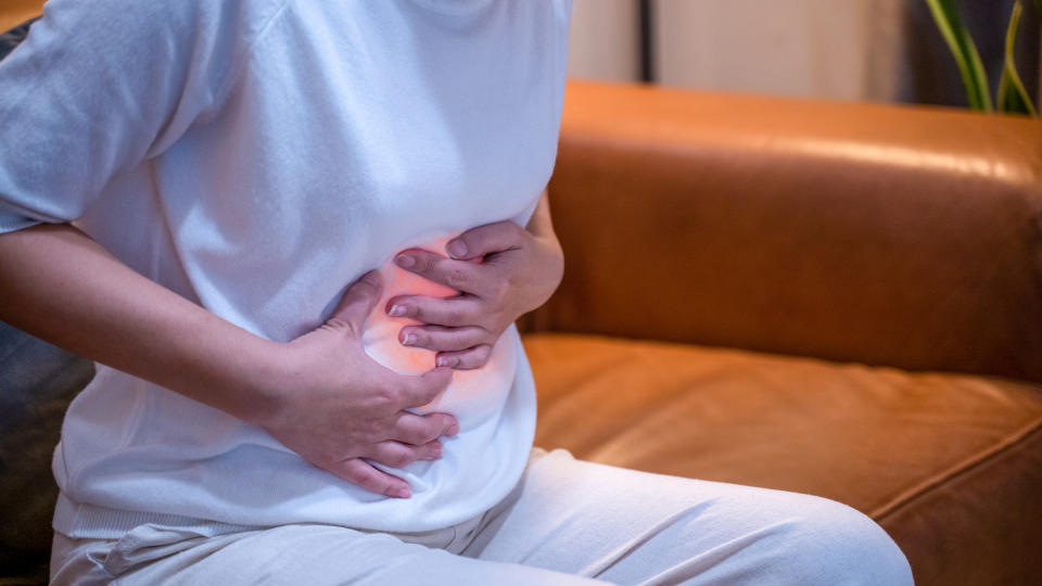 Woman touching stomach painful suffering from stomachache.Pain in red colour.