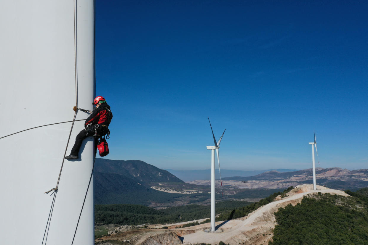 IZMIR, TURKEY - FEBRUARY 19:  Rope access technicians carry out maintenance service on wind turbines including repairs, blade inspections and cleaning in Izmir, Turkey on February 19, 2021. In Turkey, where investments in renewable energy has increased, there are wind tribunes over 3,500. Turbines, where huge cranes and high platforms are used during the installation phase, require routine maintenance and repair work in certain periods. Technicians, who arrive at the wind park, stop the turbines to be maintained and repaired and the field mission of rope access technicians begins. The work of crews descending from a height of approximately 100 meters to perform maintenance and repair work take approximately 1 hour on each wing. (Photo by Mahmut Serdar Alakus/Anadolu Agency via Getty Images)