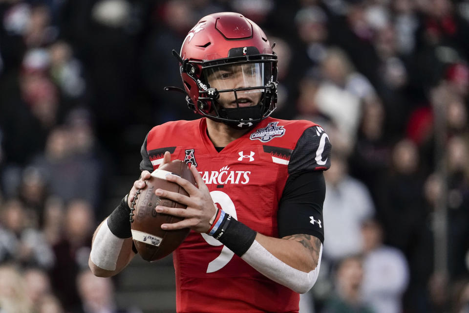 Cincinnati quarterback Desmond Ridder (9) looks to pass from  the pocket during the first half of the American Athletic Conference championship NCAA college football game against Houston Saturday, Dec. 4, 2021, in Cincinnati. (AP Photo/Jeff Dean)