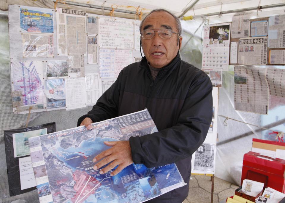 In this Thursday, Feb. 6, 2014 photo, Hiroshi Ashitomi, a retired welfare case worker, shows a protest map of Henoko where the U.S. and Japan agreed to relocate Marine Corps Air Station Futenma and plan to build an airstrip in the water dugongs and other sea creatures inhabit at his tent on the beach in Nago, Okinawa. For 10 years, He has been coming to the beach near his Okinawa home every day to sit. He loves nothing more than the sea around the island, the rare sightings of dugongs and sea turtles, the tan-colored sand and the crags out by the breakwater. Like many Okinawans, including leading politicians and media, Ashitomi opposes a plan to move the controversial Marine base to a less crowded part of the southern Japanese island. The proposed location for the new airstrip - Ashitomi’s favorite beach - is the epicenter of the opposition. (AP Photo/Eric Talmadge)