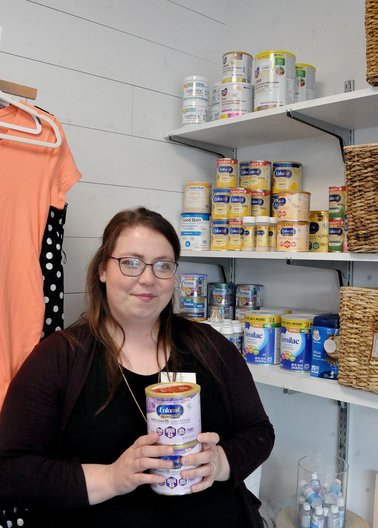 Client Services Director Jennifer Scott holds some of the baby formula that the Pregnancy Care Center of Wayne County has in stock. Center Director Rebekah Hilty said the agency has seen both increased donations and need from the community since the shortage began earlier this year.