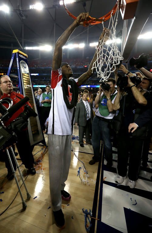 Louisville Cardinals' Kevin Ware cuts the net after Louisville defeat the Michigan Wolverines 82-76 on April 8, 2013. Ware cut the net from the rim after the game, a celebratory tradition aided by lowering the backboard to allow for his broken leg