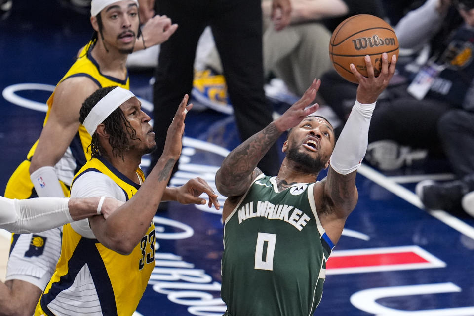 Milwaukee Bucks guard Damian Lillard (0) shoots around Indiana Pacers center Myles Turner (33) during the first half in Game 2 in an NBA basketball first-round playoff series, Friday, April 26, 2024, in Indianapolis. (AP Photo/Michael Conroy)