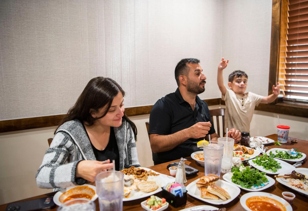 Ravand Al Dosaki eats with his wife, Vammon Hassan, and their son, Alan Ihsan, 4, at Hassan's family’s restaurant House of Kabob in Nashville, Tenn., Tuesday, Oct. 24, 2023.