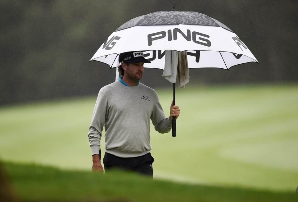 Bubba Watson holds an umbrella while walking down the fairway of the first hole during the Final round of the Zozo Championship golf tournament at Sherwood Country Club in Thousands Oaks, California.