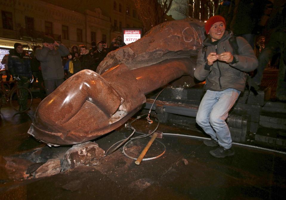 People surround a statue of Soviet state founder Vladimir Lenin, which was toppled by protesters during a rally organized by supporters of EU integration in Kiev, December 8, 2013. Crowds toppled a statue of Soviet state founder Vladimir Lenin in the Ukrainian capital and attacked it with hammers on Sunday in the latest mass protests against President Viktor Yanukovich and his plans for closer ties with Russia. REUTERS/Stoyan Nenov (UKRAINE - Tags: POLITICS CIVIL UNREST)