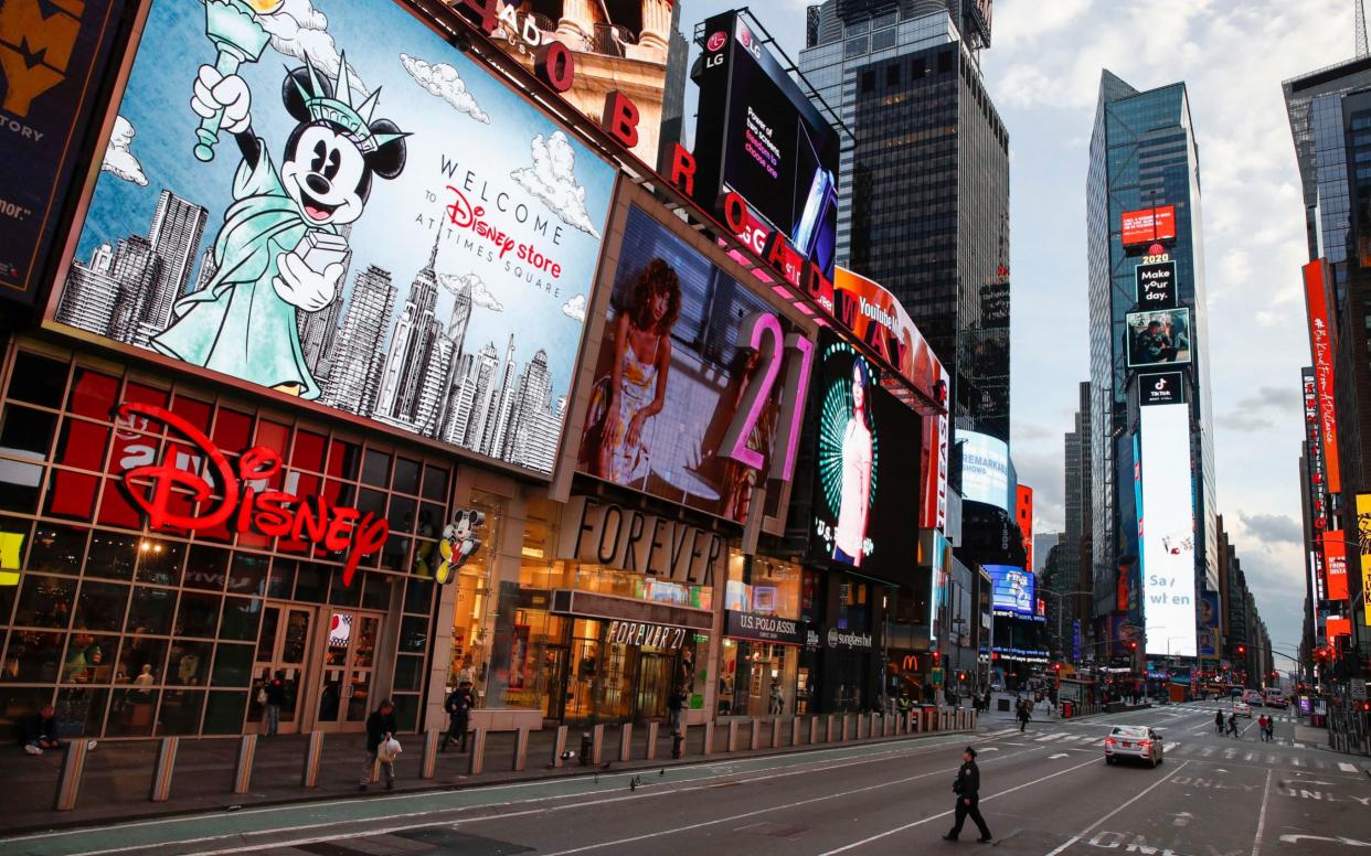 A police officer walks across an empty Seventh Avenue in New York City - AP Photo/John Minchillo, File