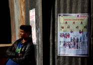 A man stands next to the instruction posters displayed by the Election Commission near the polling station, a day ahead of the parliamentary and provincial elections in Kathmandu, Nepal December 6, 2017. REUTERS/Navesh Chitrakar