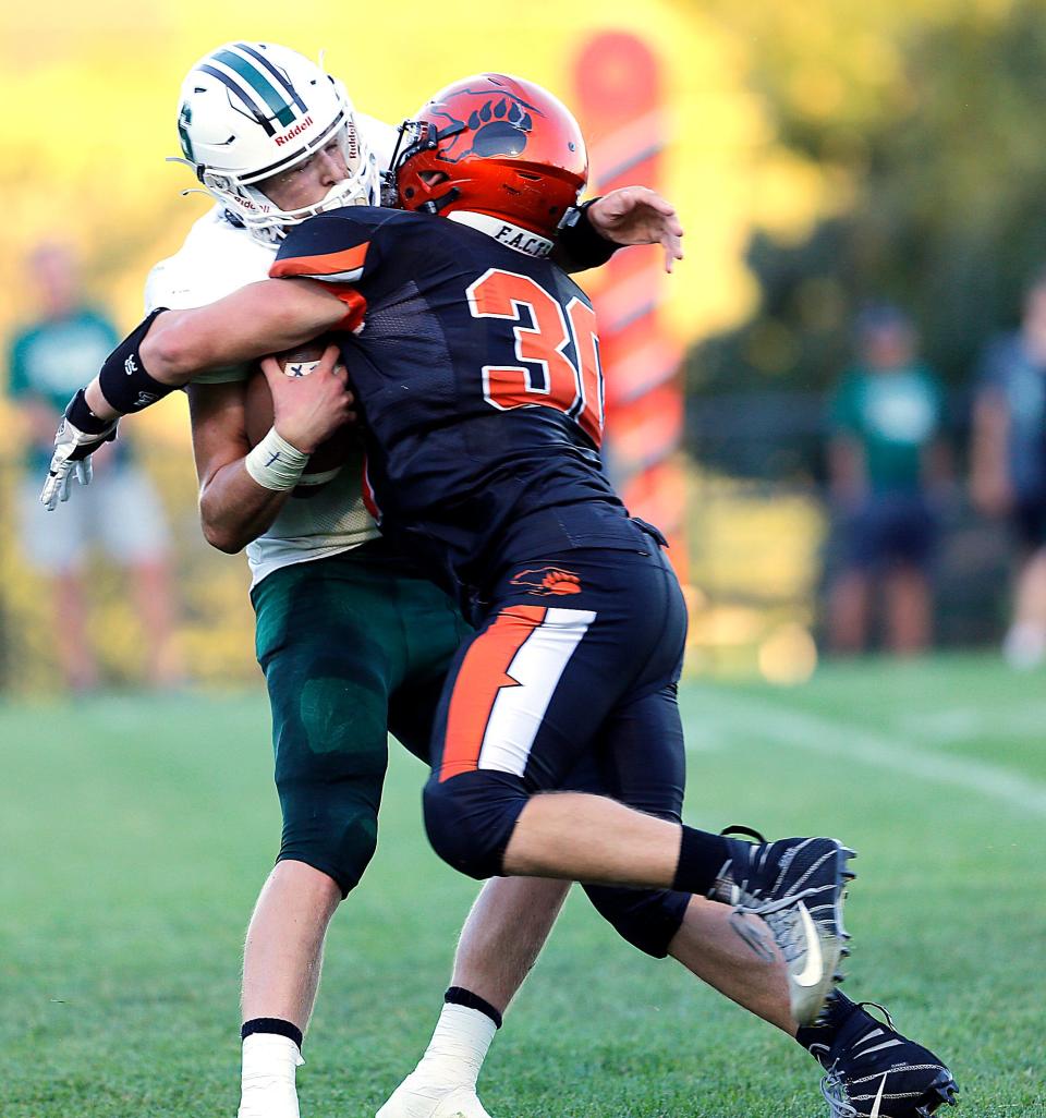 Lucas High School's Daniel Hockensmith (30) sacks Smithville High School quarterback Bryce Butcher (2) during high school football action at Lucas High School, Friday, Sept. 1, 2023. TOM E. PUSKAR/MANSFIELD NEWS JOURNAL