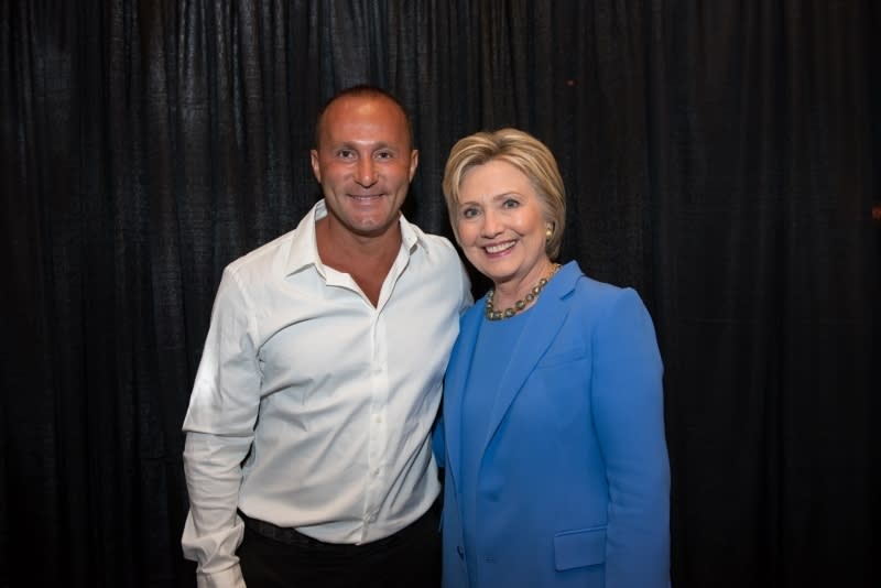 This image from the website of Allied Wallet CEO Ahmad "Andy" Khawaja shows Khawaja posing with Hillary Clinton. Records obtained by The Associated Press show that Khawaja, a prominent political donor has helped pornographers, payday loan debt collectors and offshore gambling operations get past the gates of the banking system. Los Angeles-based Allied Wallet, its executives and Khawaja have given $6 million in campaign contributions to Republicans and Democrats since late 2015. The records show the company used fake websites and foreign dummy corporations to mask some customers’ true business. (Andy Khawaja via AP)