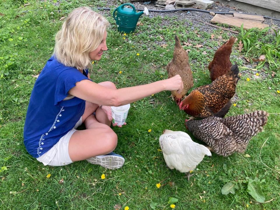 Author Courtenay Rudzinski feeding chickens