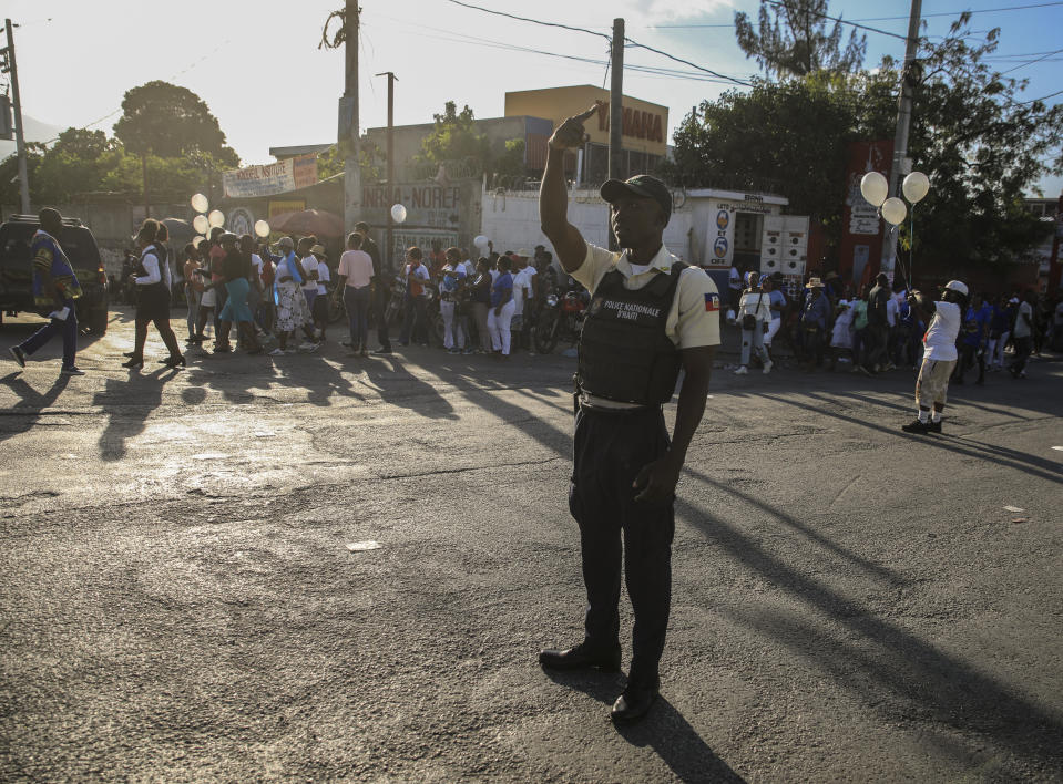 A member of the national police controls security on a street in Port-au-Prince, Haiti, Saturday, Jan. 21, 2023. One of Haiti's gangs stormed a key part of the capital, Port-Au-Prince, and battled with police throughout the day, leaving at least three officers dead and another missing. (AP Photo/Odelyn Joseph)